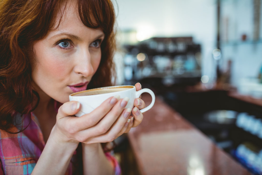 woman drinking a large cup of coffee
