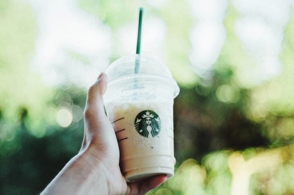 a hand holding a cup of Starbucks cold brew
