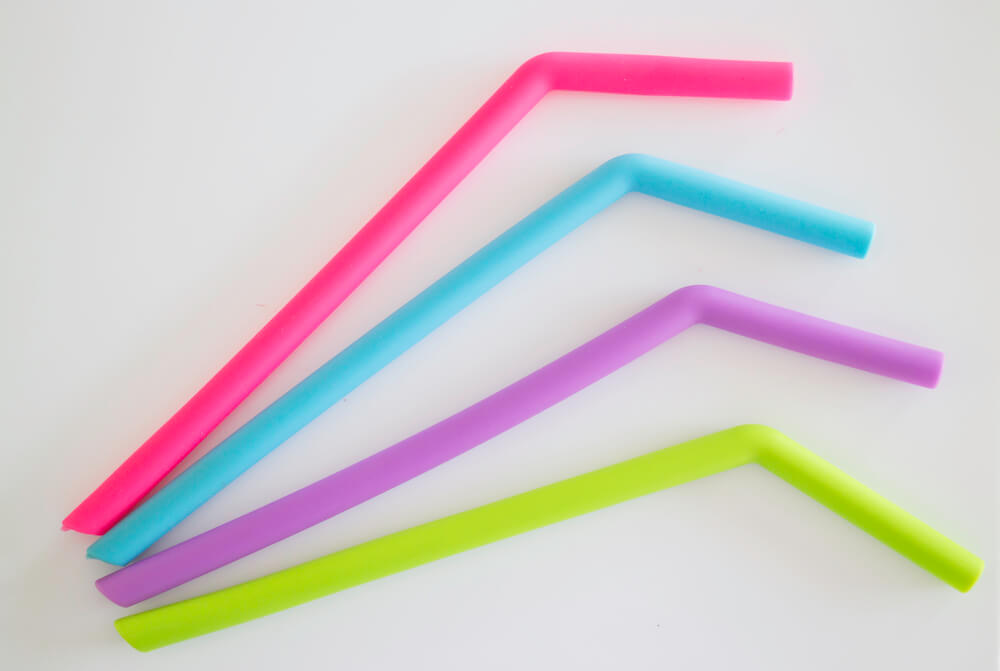 a close-up shot of four colorful silicone straws