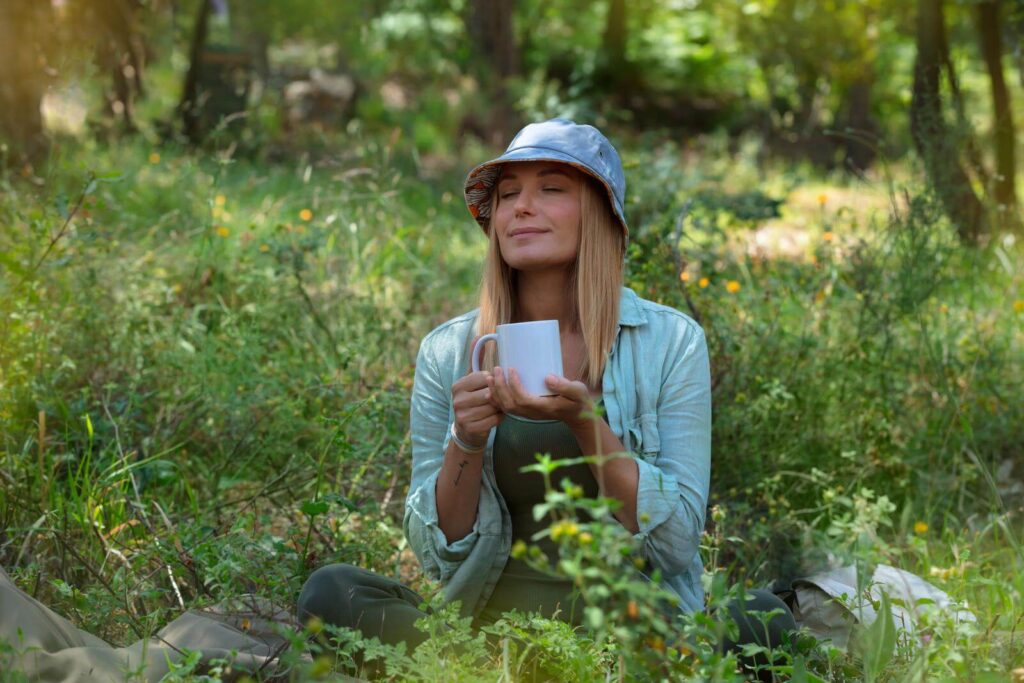 woman enjoying her coffee in the middle of camping