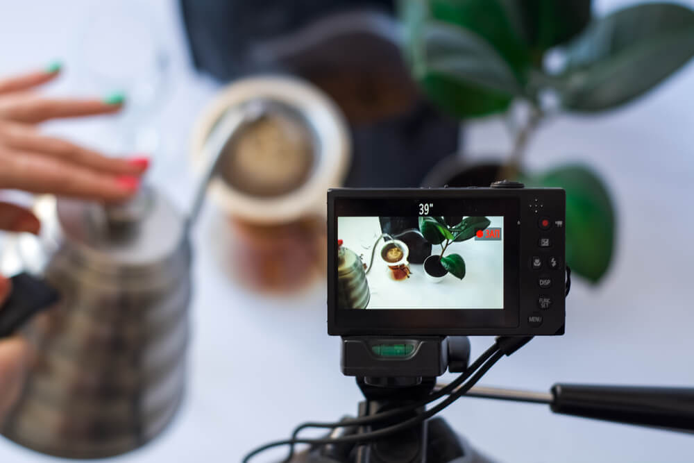 Recording video on the camera on tripod of coffee preparation process