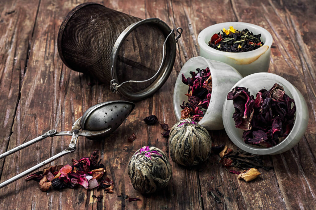 tea strainer and different varieties of tea leaves