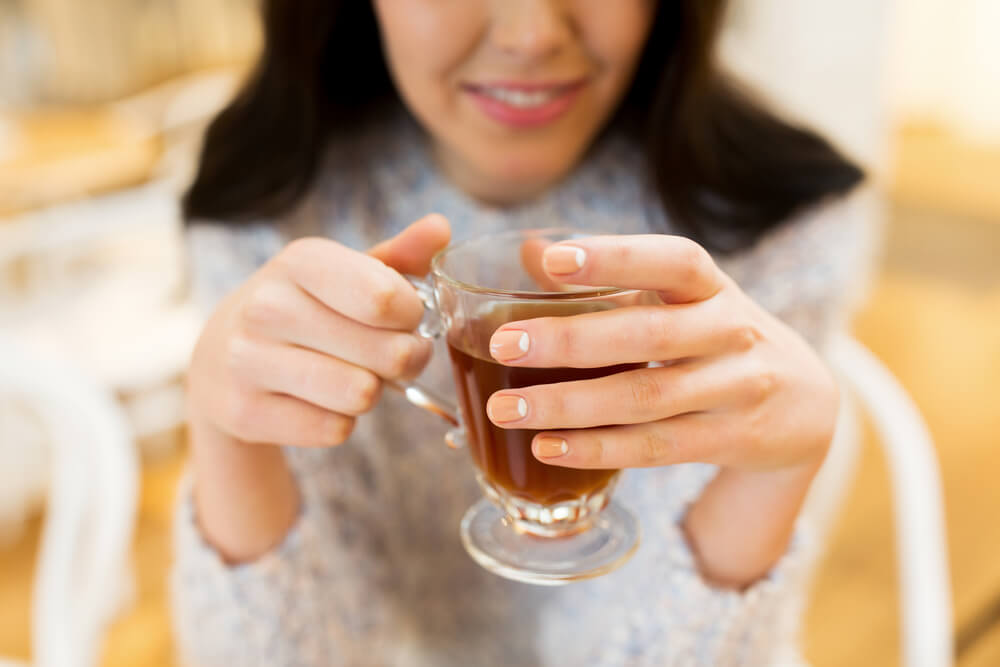 a close-up shot of a woman holding a tea