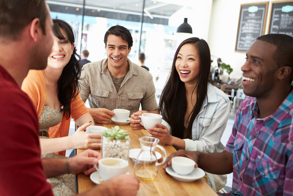 group of friends talking happily while in a coffee shop