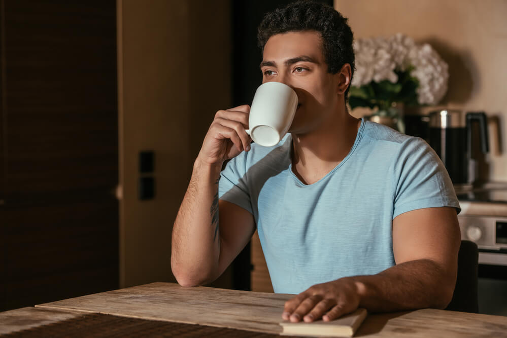 young man sipping a cup of coffee