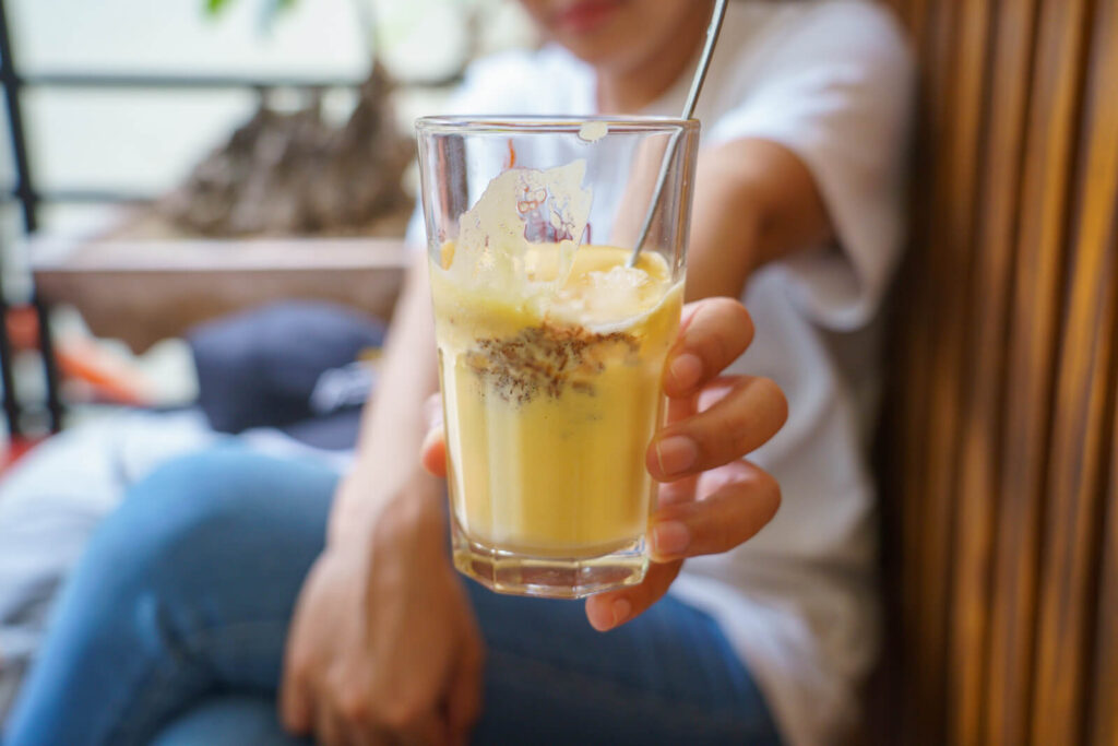 blurred picture of a woman holding a Vietnamese egg coffee