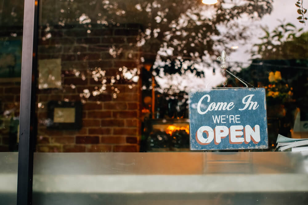 open sign in a coffee shop - why you should open a coffee shop
