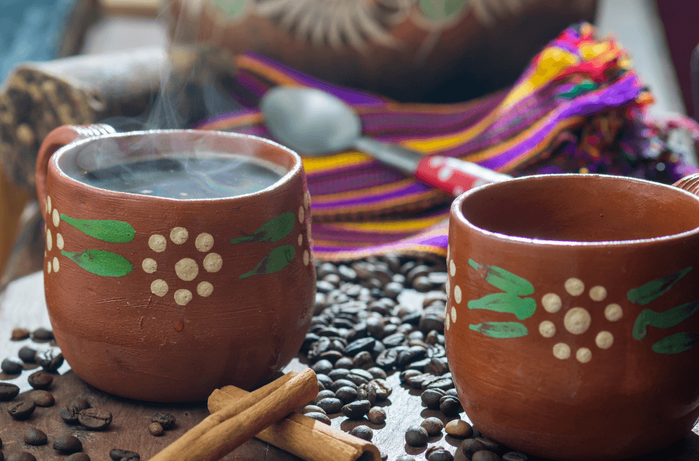 Clay pot mug with a cinnamon roll and coffee beans in the table