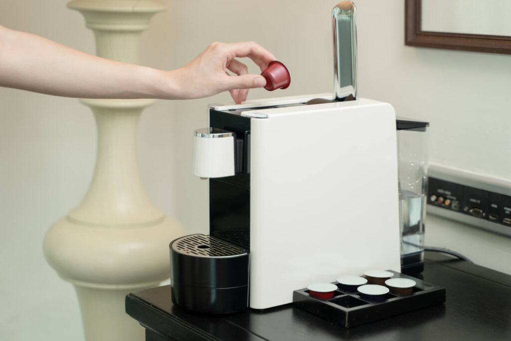 Woman hand pressing button on a capsule