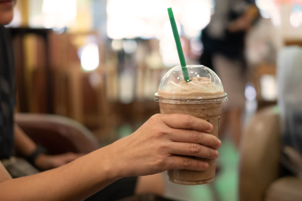 Woman holding a plastic glass of iced coffee