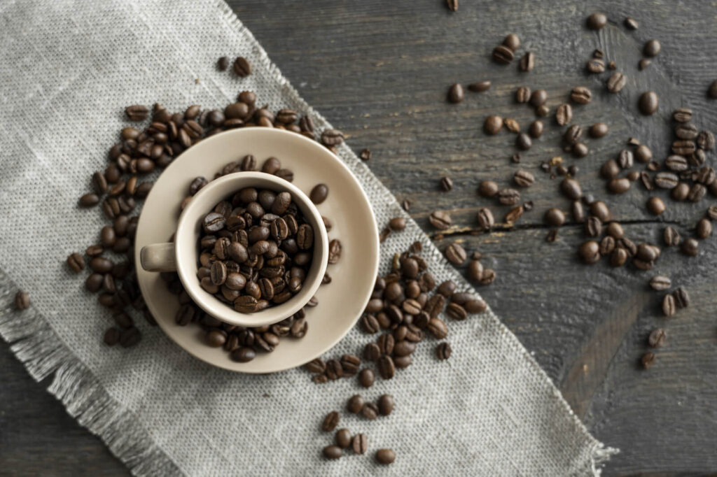 A coffee cup filled with fresh robusta coffee beans 
