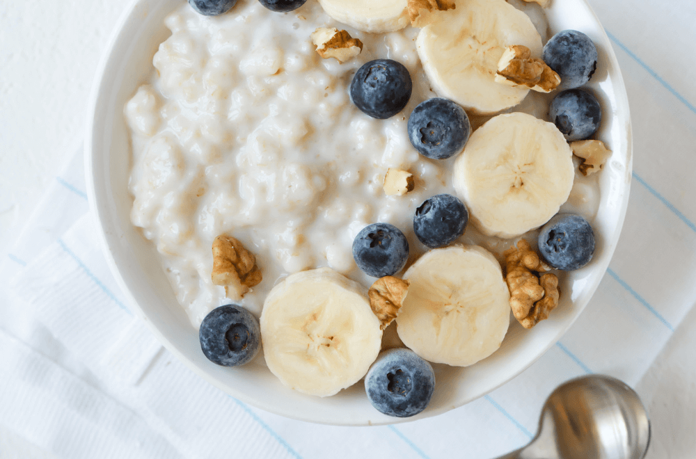 Oatmeal with nuts and fruits in white bowl