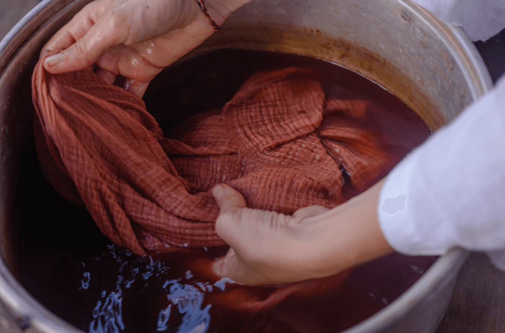Woman's hand soaked fabric in aluminum basin