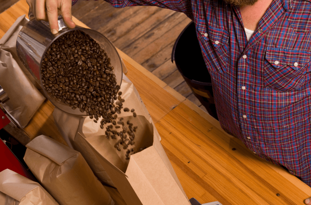 Close-up of a man packing coffee beans into the coffee bag 