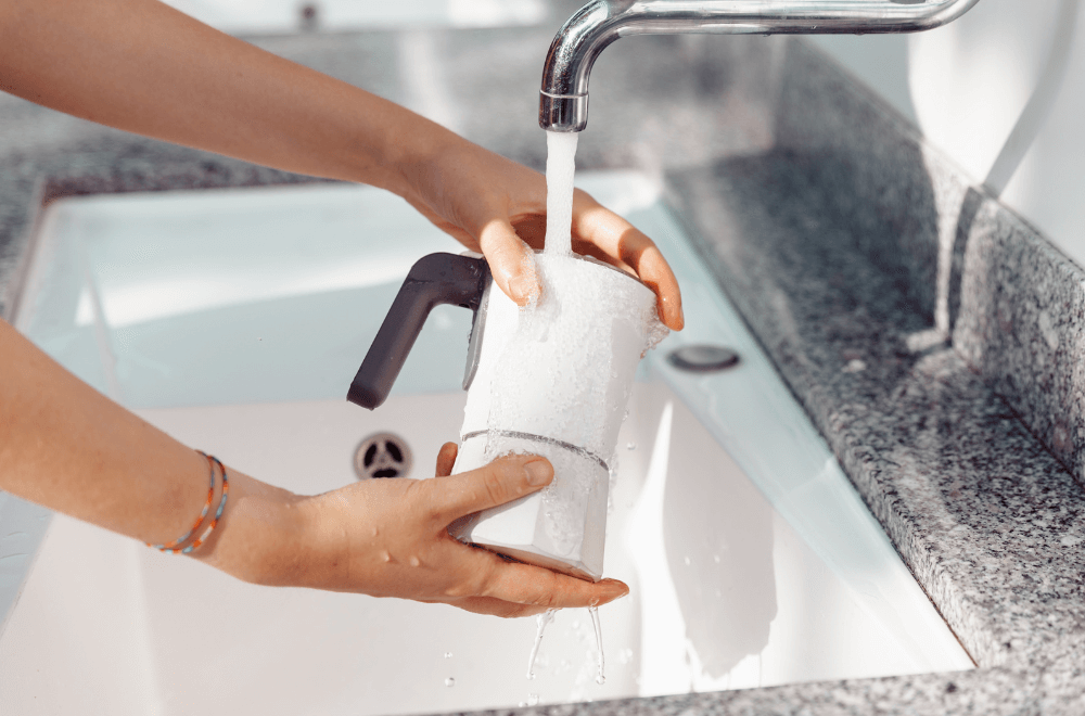 Cleaning a moka pot under a stream of water after use