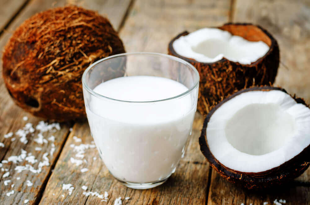 A glass of coconut milk on a wooden table