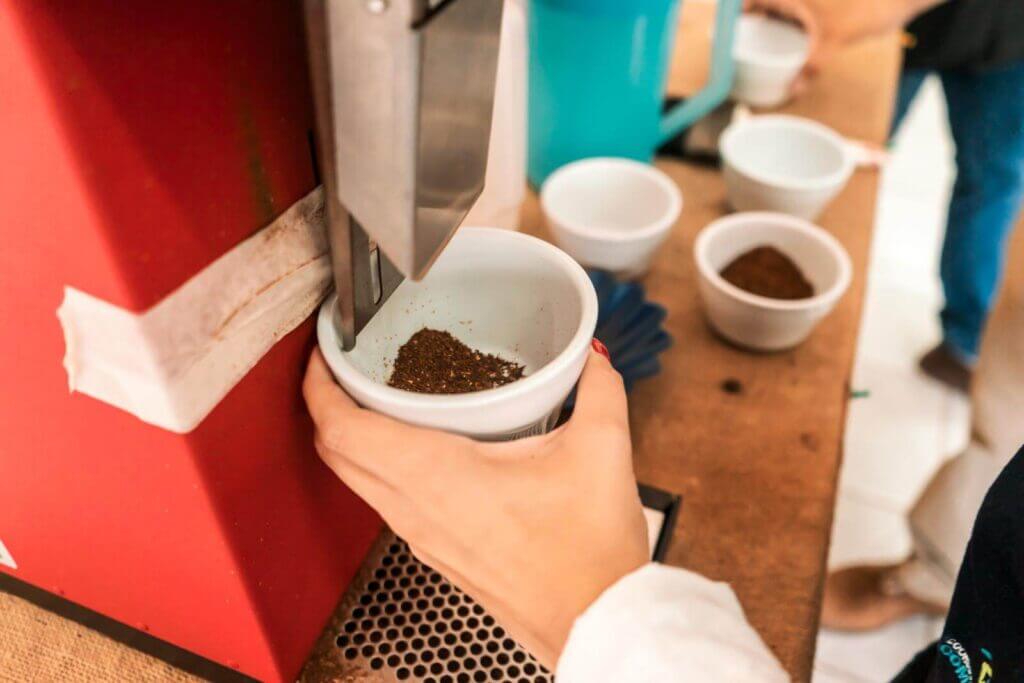 Closeup of the hand of a woman grinding coffee in a machine