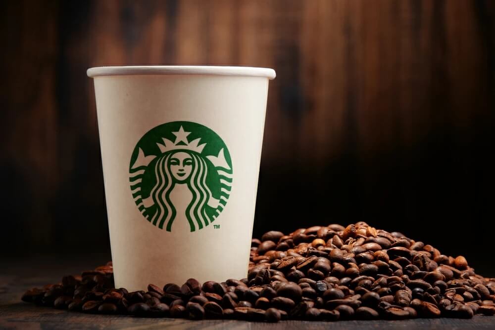 A Starbucks coffee with coffee beans beside it