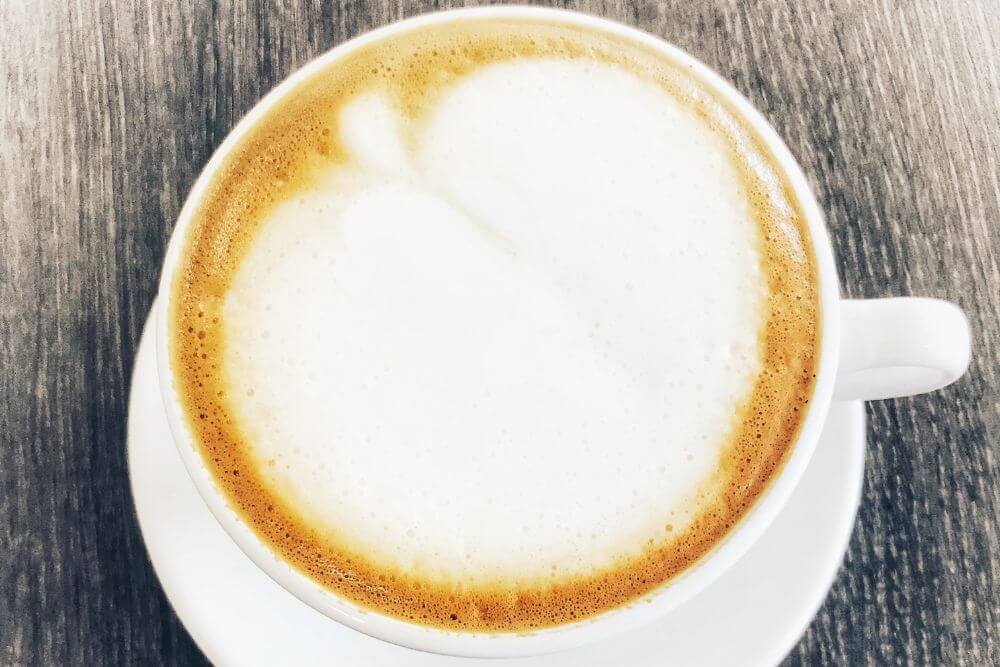 Fresh flat white coffee on wood table