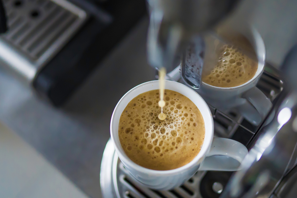 Espresso shot and coffee foam in white mug from espresso machine