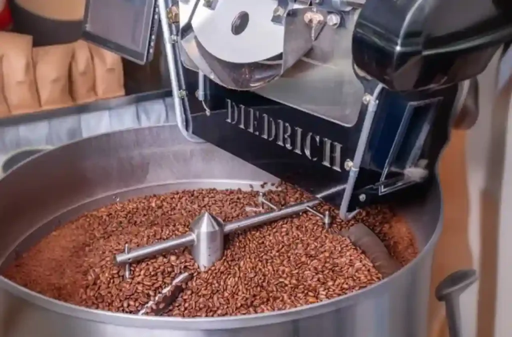 A Diedrich roaster filled with coffee beans in a coffeeshop