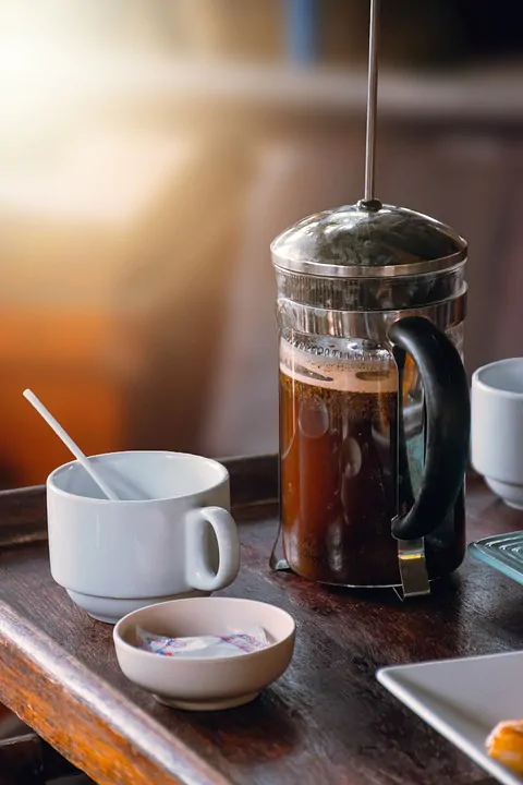 French press coffee at center of a wooden block