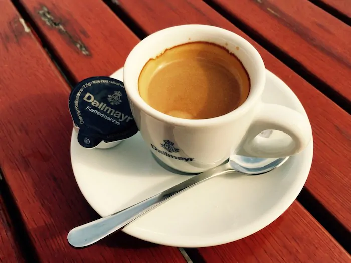 A cup of espresso coffee sitting on top of a wooden table