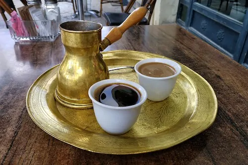 Turkish coffee on a table with a coffee pot.
