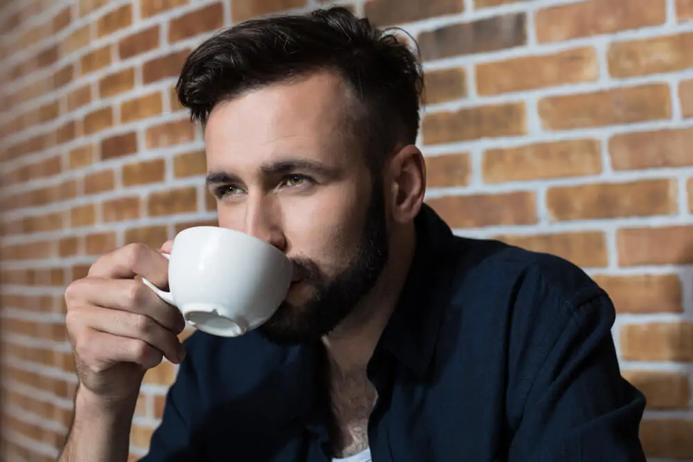 young bearded man drinking coffee