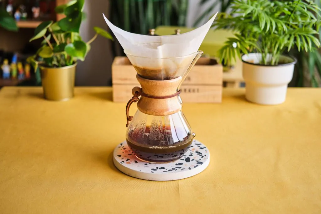 A Chemex coffee maker standing at the middle of the table