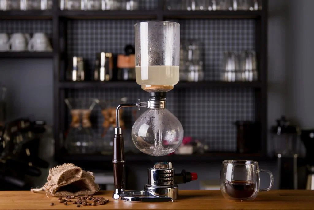 siphon coffee, a cup of coffee, and coffee beans