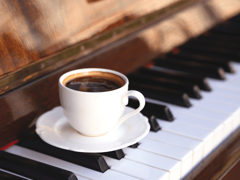 A cup of coffee on a piano.
