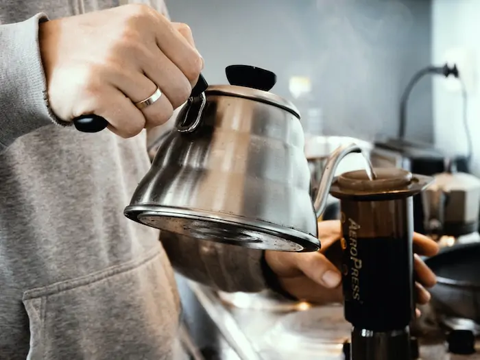 A person pouring from a coffee pot.