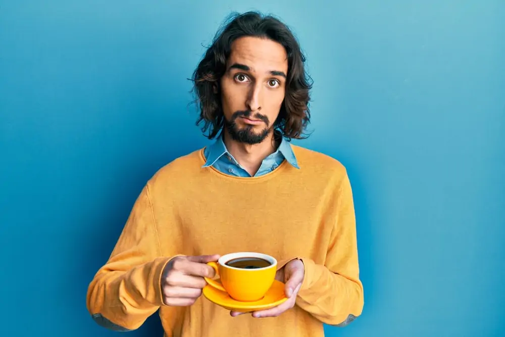 A person holding a cup, with Coffee
