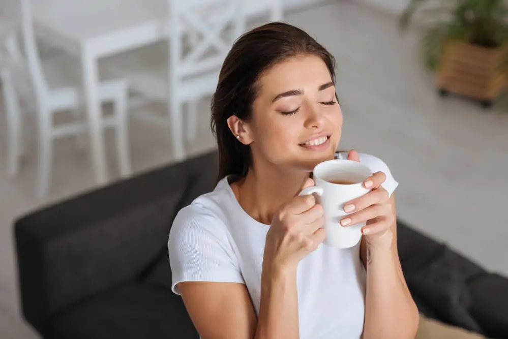 woman smelling her coffee