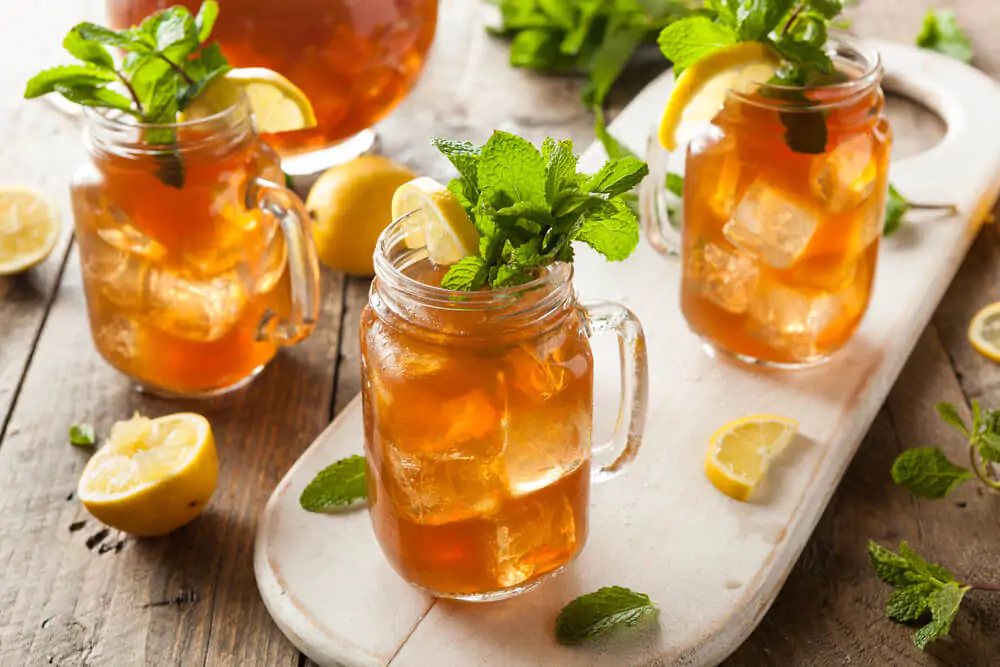 boozy sweet tea - homemade iced tea filling three large containers