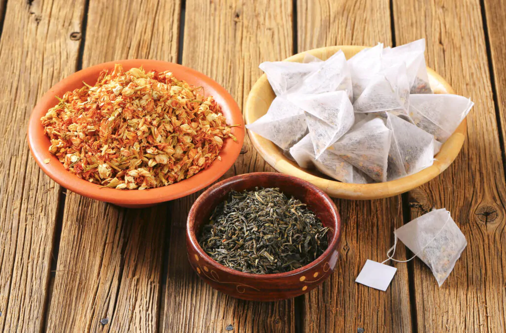 Dried jasmine leaves and flowers and pyramid tea bags