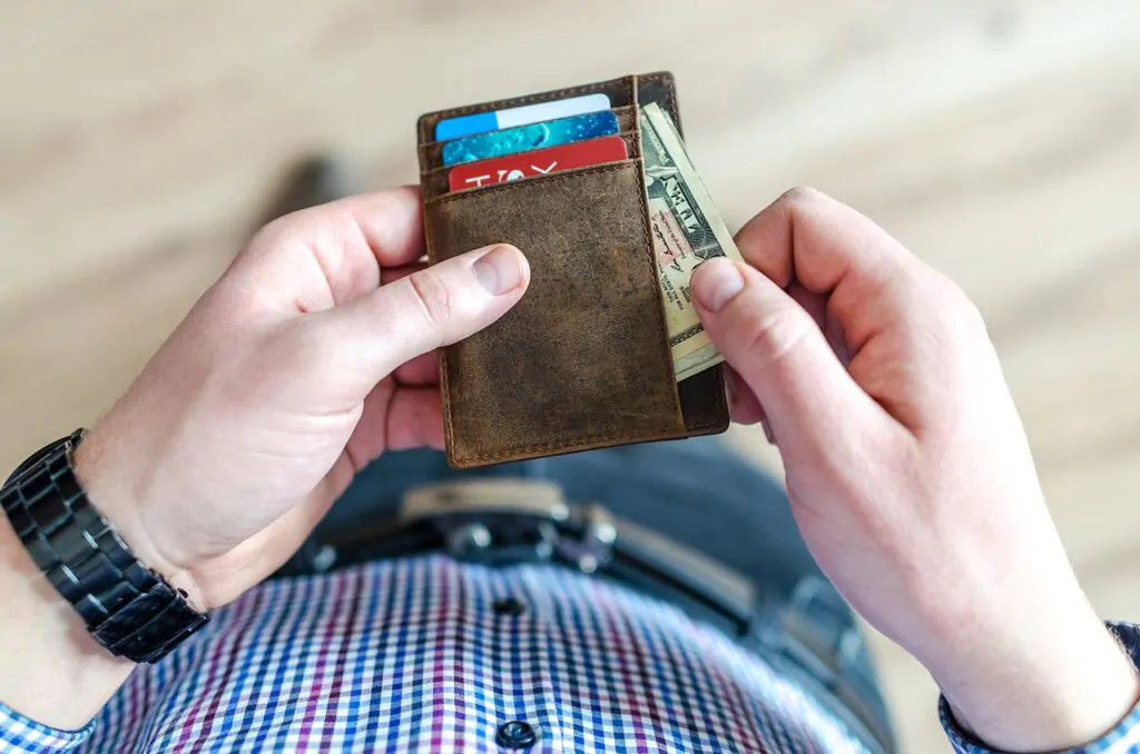 a man taking a money bills off his wallet