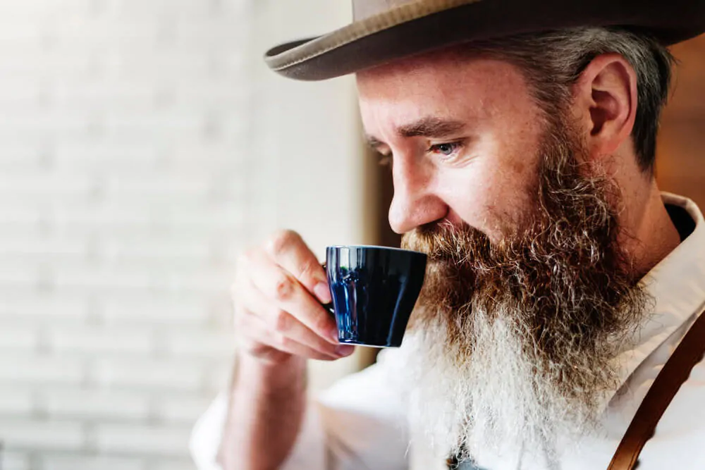 bearded man enjoying his coffee