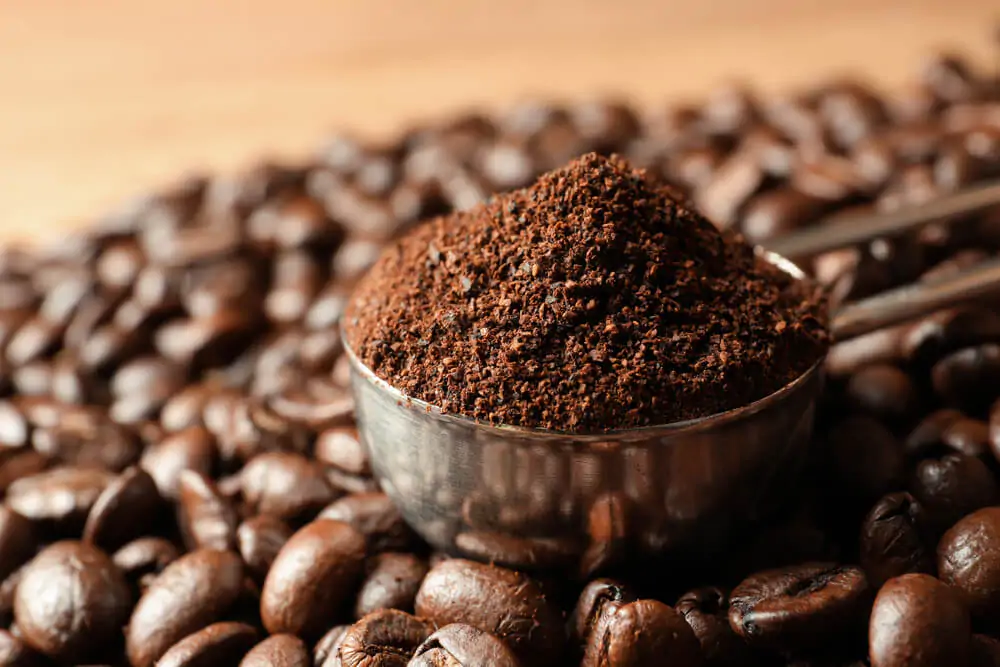 ground coffee surrounded by coffee beans