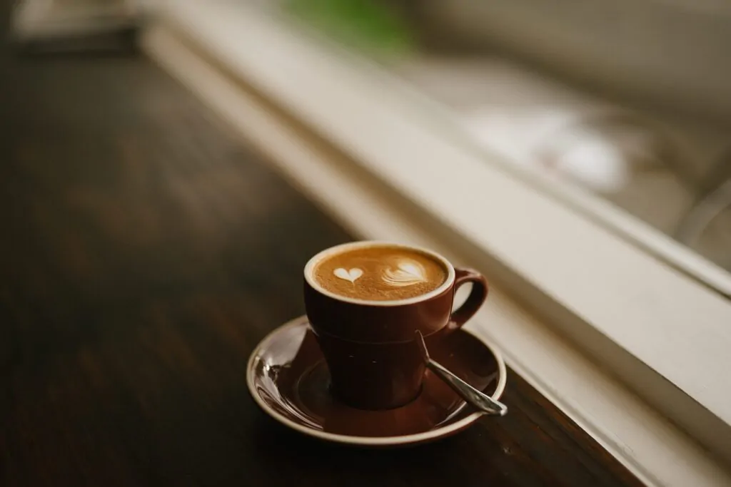 freshly brewed cappuccino coffee on a brown cup