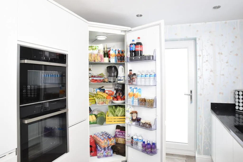 open refrigerator with lots of food and drinks