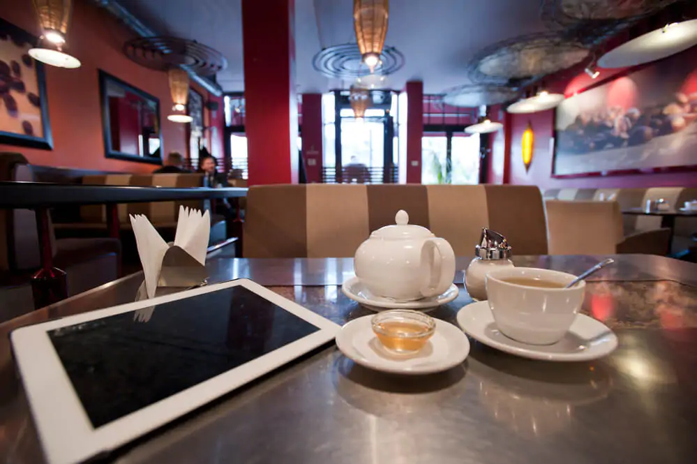 an iPad and a coffee on a table inside a coffee shop