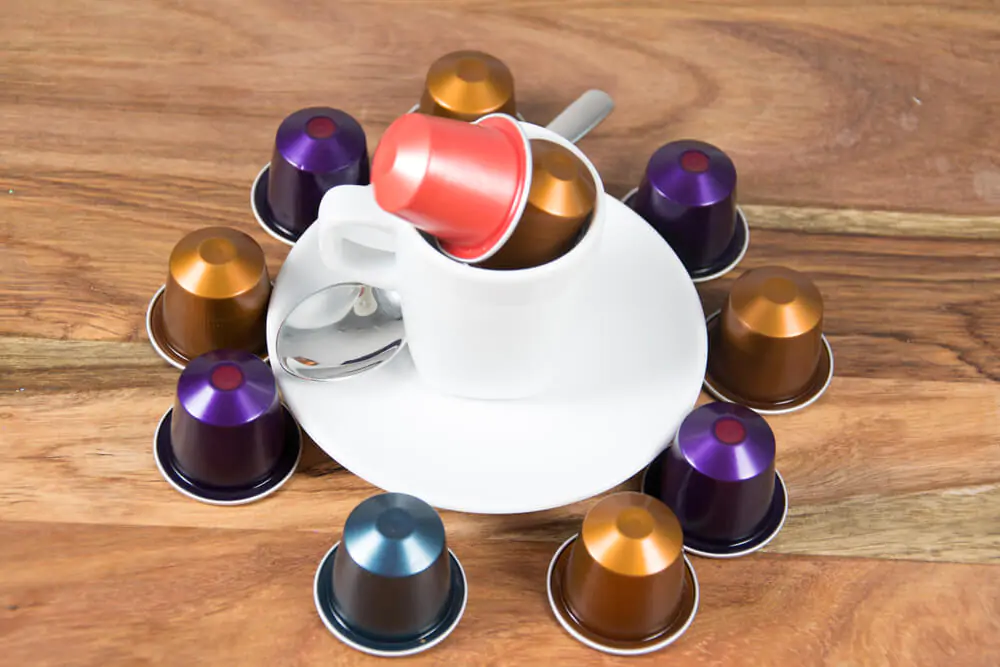 Coffee pods surrounding a white plate.