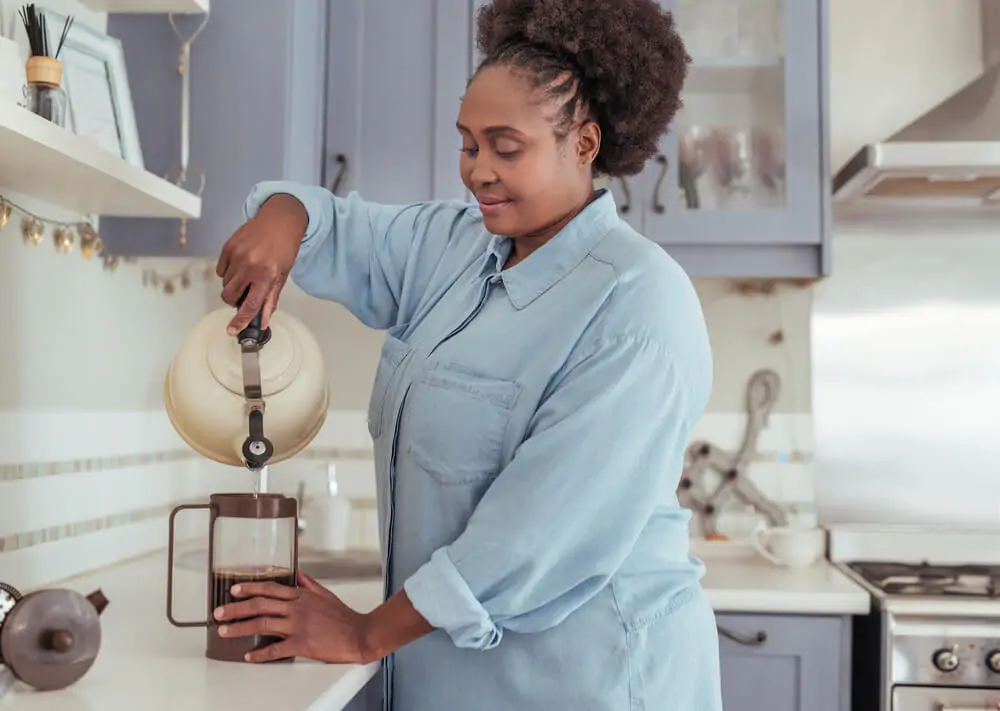 woman preparing French press coffee - Coffee To Water French Press Ratio