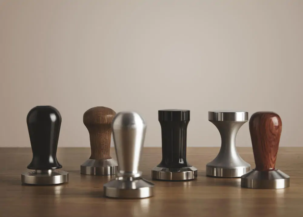 Various coffee tampers on table
