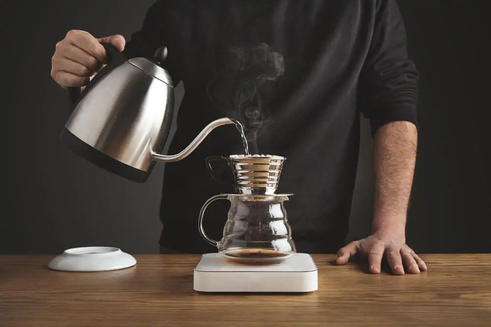 A man pouring hot water to drip coffee maker