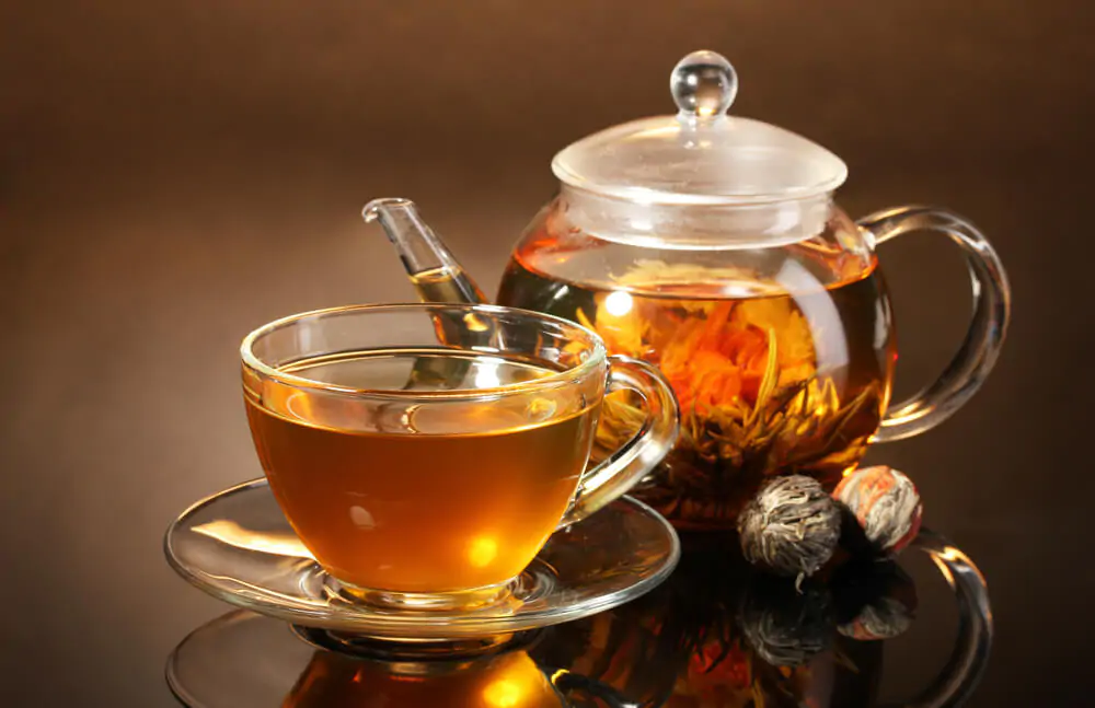 Can You Make Tea In A Moka Pot - A cup of tea and a brewed tea on a teapot