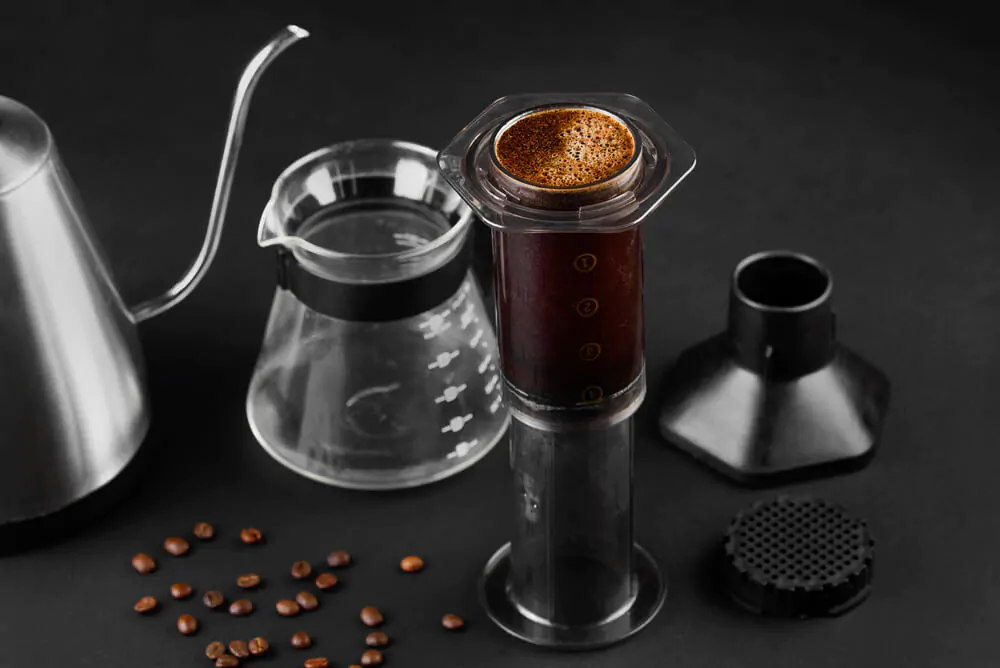 Aeropress vs. delter coffee maker. Aeropress in a black background.