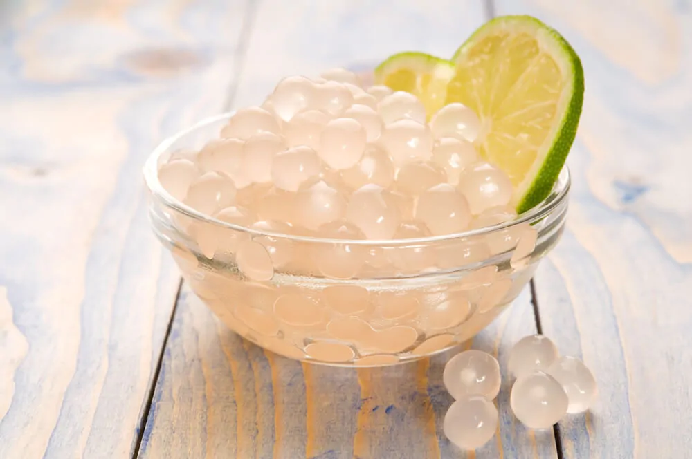 White tapioca pearls in a bowl with a slice of lime
